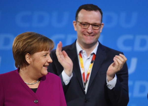 © dpa. Merkel en Spahn tijdens het CDU-congres