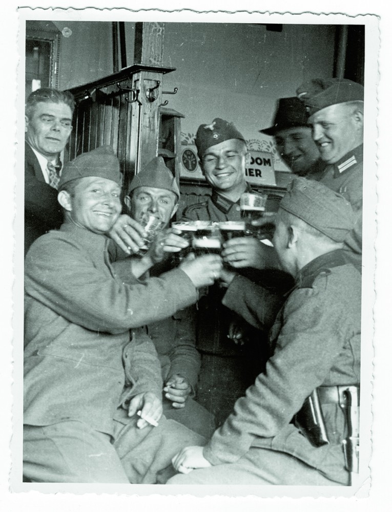 Na de gevechten in de meidagen proosten Nederlandse en Duitse soldaten breed lachend in een café. Afb.: WBooks Zwolle/Gerard Groeneveld