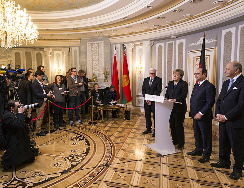 Merkel en Hollande in Minsk, met hun ministers Steinmeier en Fabius. Afb.: Steffen Kugler/Bundesregierung/dpa
