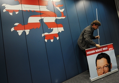De verkiezingsposter van SPD-kandidaat Schäfer-Gümbel wordt opgeruimd. Afb.: dpa