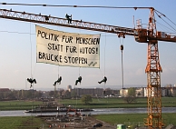 Politik für Menschen statt für Autos, Brücke stoppen: demonstranten maken hun onvrede over de bouw van de Elbebrug kenbaar. Onderaan zijn de fundamenten van het omstreden bouwproject te zien. Afb: DPA/Picture Alliance