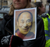 Een vrouw toont demonstratief een foto van de Dalai Lama tijdens de tocht van de Olympisch vlag door Londen op 8 april 2008. Afbeelding: stemy, www.flickr.com